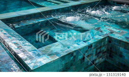 Luxury resort pool with overflowing water feature in turquoise 131319140