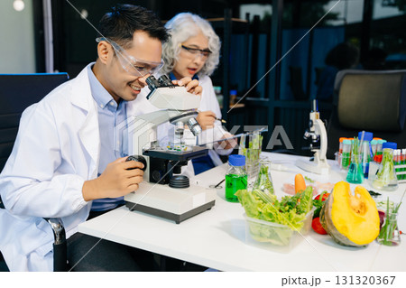 Team Asian scientists in a lab conducting food research using a microscope and lab equipment, showcasing innovation 131320367