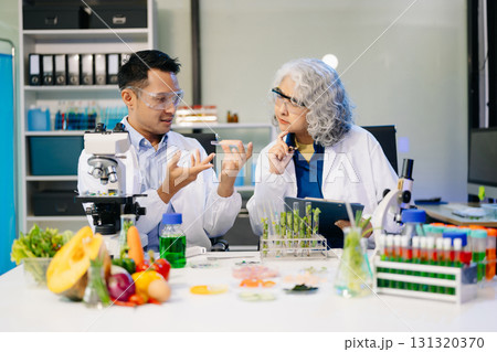 Team Asian scientists in a lab conducting food research using a microscope and lab equipment, showcasing innovation 131320370