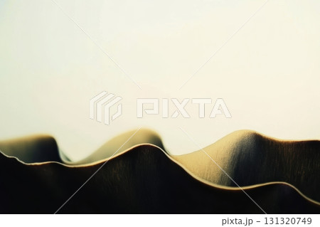 Textured fabric waves create a soft visual flow in warm light 131320749