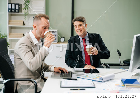 Professionals brainstorming and analyzing charts during a business meeting. Highlighting teamwork, Professionals brainstorming and analyzing charts during a business meeting. Highlighting teamwork, 131321327