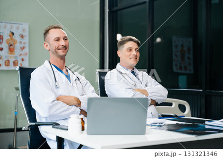 Doctors analyzing an X-ray, collaborating with digital tools in a medical office. Showcasing teamwork, diagnostic 131321346