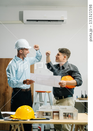 Architects and designers collaborating on models and plans, brainstorming innovative structures 131321598