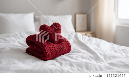 Red knitted heart on a cozy white bed for Valentine's Day Red knitted heart on a cozy white bed for Valentine's Day 131321625