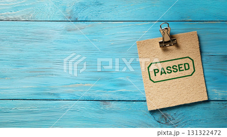 Passed note on clipboard against blue wooden background Passed note on clipboard against blue wooden background 131322472