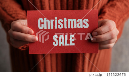 Christmas sale announcement with red card and hands holding it 131322676