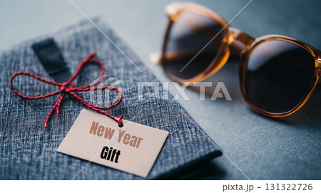 New Year gift with sunglasses on textured surface, perfect for celebrations New Year gift with sunglasses on textured surface, perfect for celebrations 131322726