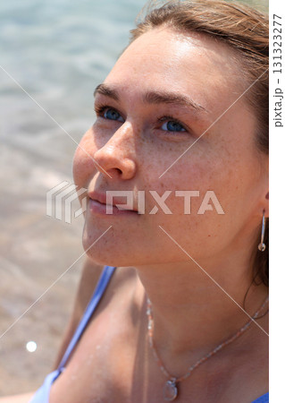 Woman looking upwards near water 131323277