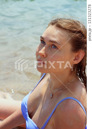 Woman in blue swimsuit by water Woman in blue swimsuit by water 131323278