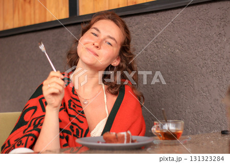 Woman enjoying dessert at cafe 131323284