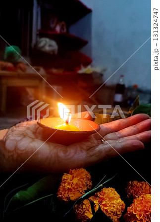 Woman Hand Holding a Lit Clay Diya 131324747