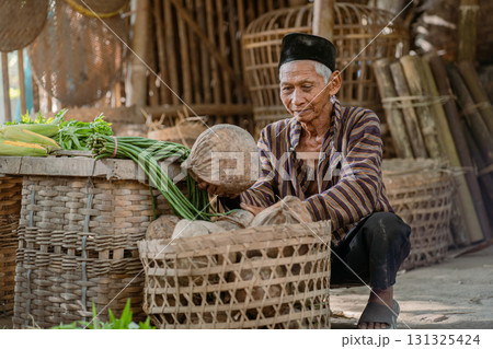 An Elderly Man Dedicated to Sorting Fresh Vegetables in a Traditional Market Setting An Elderly Man Dedicated to Sorting Fresh Vegetables in a Traditional Market Setting 131325424
