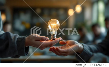 A person holding a light bulb, symbolizing ideas and collaboration in a brainstorming session or classroom setting 131326139