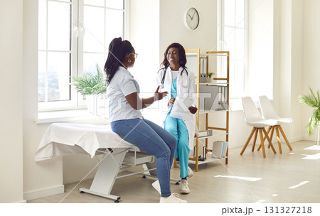 Young African American female doctor and patient talking in the examination room Young African American female doctor and patient talking in the examination room 131327218