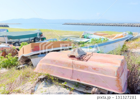 海辺に廃棄された小舟と防波堤 131327281