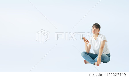 座ってスマホを使うカジュアルウェアを着た10代女性の切り抜き全身写真 座ってスマホを使うカジュアルウェアを着た10代女性の切り抜き全身写真 131327349