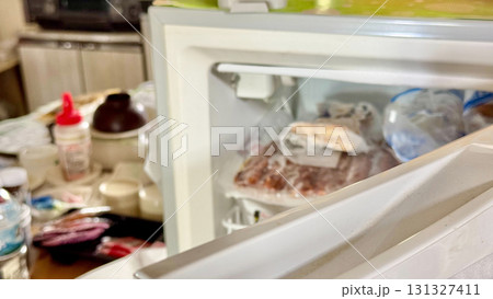 台所で扉の開いた冷凍庫 131327411