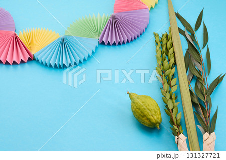 Colorful Sukkot Composition. Festive Sukkot arrangement with lulav, etrog, and vibrant paper decorations 131327721
