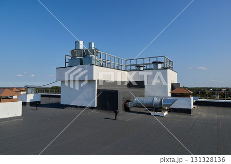 A Modern Rooftop Industrial HVAC System sits beneath a Clear Blue Sky during the day 131328136