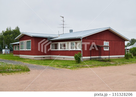 A Traditional Red Wooden House in a picturesque rural setting, surrounded by nature 131328206