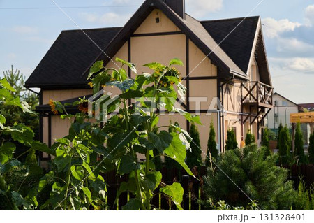 A Charming House Nestled Amidst Lush Greenery and Vibrant Sunflowers, Perfect for Tranquility 131328401