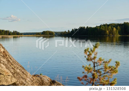 A Beautiful and Serene Lakeside View featuring Lush Greenery and Calm, Reflective Waters A Beautiful and Serene Lakeside View featuring Lush Greenery and Calm, Reflective Waters 131328508