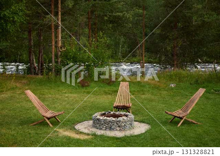 A Serene and Inviting Outdoor Fire Pit Area Surrounded by Lush Nature and Greenery A Serene and Inviting Outdoor Fire Pit Area Surrounded by Lush Nature and Greenery 131328821