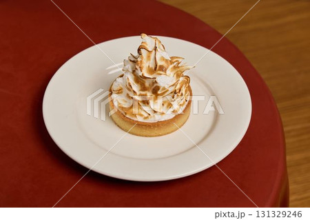 Indulge in a Delicious Meringue Tart elegantly presented on a Beautiful Plate for Dessert Indulge in a Delicious Meringue Tart elegantly presented on a Beautiful Plate for Dessert 131329246
