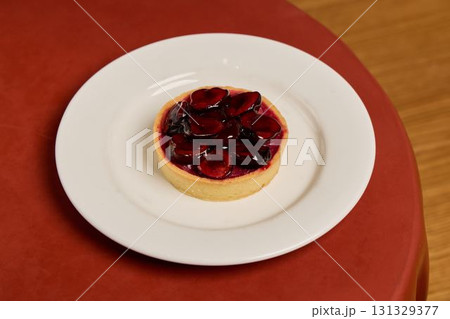 A beautifully presented and delicious Cherry Tart displayed on a lovely white plate 131329377