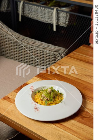 An Elegant and Artistic Plate of a Gourmet Meal Beautifully Presented on a Wooden Table An Elegant and Artistic Plate of a Gourmet Meal Beautifully Presented on a Wooden Table 131329430