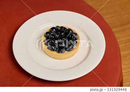 Delicious Blueberry Tart beautifully presented on a pristine white plate for all to enjoy Delicious Blueberry Tart beautifully presented on a pristine white plate for all to enjoy 131329448