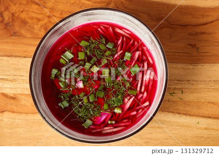 Enjoy a Vibrant Cold Beet Soup Full of Fresh Herbs and Colorful Garnish for Flavor 131329712