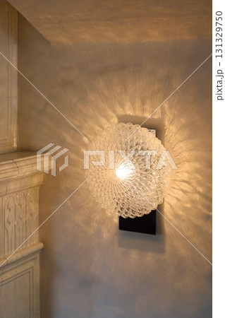This elegant glass wall sconce features a unique light pattern that adds charm and sophistication This elegant glass wall sconce features a unique light pattern that adds charm and sophistication 131329750
