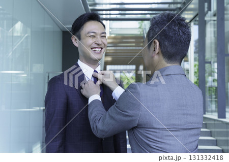 オフィスで部下のネクタイを治す男性の手元　撮影協力:スカパー東京メディアセンター 131332418