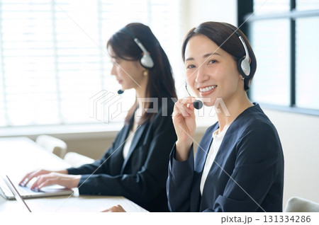 並んでコールセンターの仕事をするカメラ目線の日本人女性 並んでコールセンターの仕事をするカメラ目線の日本人女性 131334286