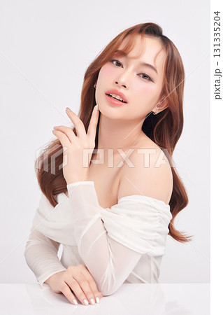 A beautiful young Asian woman with clean, fresh skin against a white background. Skincare, facial treatment, cosmetology, beauty, and spa. An elegant portrait of an Asian woman. A beautiful young Asian woman with clean, fresh skin against a white background. Skincare, facial treatment, cosmetology, beauty, and spa. An elegant portrait of an Asian woman. 131335204