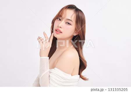 A beautiful young Asian woman with clean, fresh skin against a white background. Skincare, facial treatment, cosmetology, beauty, and spa. An elegant portrait of an Asian woman. 131335205