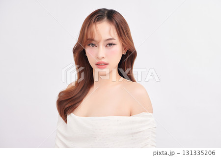 A beautiful young Asian woman with clean, fresh skin against a white background. Skincare, facial treatment, cosmetology, beauty, and spa. An elegant portrait of an Asian woman. 131335206