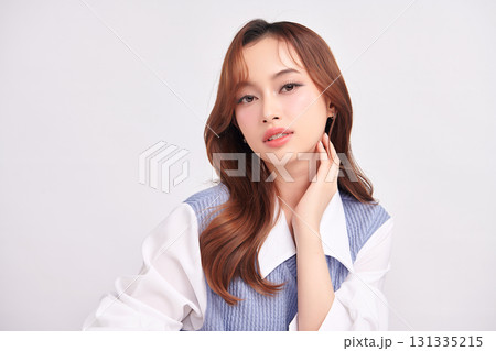 A beautiful young Asian woman with clean, fresh skin against a white background. Skincare, facial treatment, cosmetology, beauty, and spa. An elegant portrait of an Asian woman. 131335215