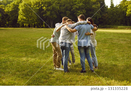 Group of people standing in circle in middle of green park and hugging each other. Group of people standing in circle in middle of green park and hugging each other. 131335228