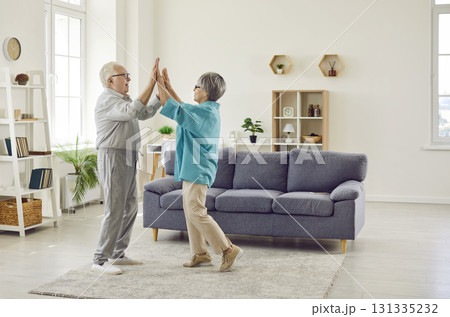 Happy married senior man and woman in love are dancing in the living room at home 131335232