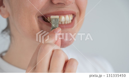 Woman Chewing Nicotine Snus Product.  131335450