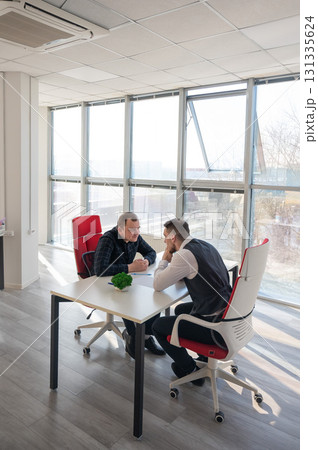 Two Caucasian men communicating at a business meeting.  131335624