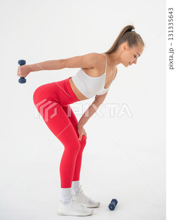 Young woman doing exercise with dumbbells on white background. Young woman doing exercise with dumbbells on white background. 131335643