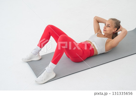 Young woman doing abdominal exercises on white background. 131335656