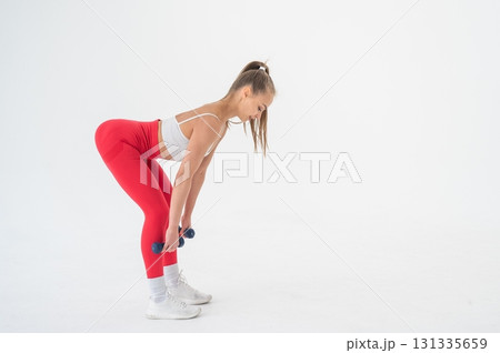 Young woman doing exercise with dumbbells on white background. 131335659