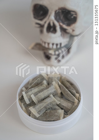 Skull Chewing Tobacco on a White Table. 131335675