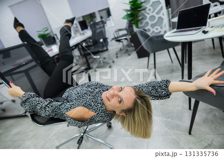 Caucasian woman having fun and lying on office chair.  131335736