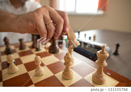 Close up of hands of middle aged caucasian man playing chess. Close up of hands of middle aged caucasian man playing chess. 131335798