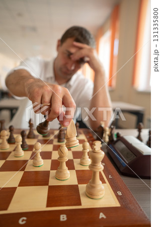 Middle aged Caucasian man playing chess.  131335800